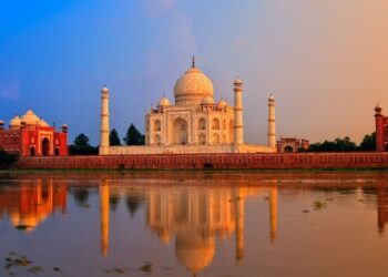 Taj Mahal at sunrise reflected in water, a UNESCO monument central to heritage travel in India