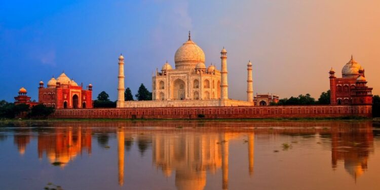 Taj Mahal at sunrise reflected in water, a UNESCO monument central to heritage travel in India