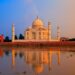 Taj Mahal at sunrise reflected in water, a UNESCO monument central to heritage travel in India