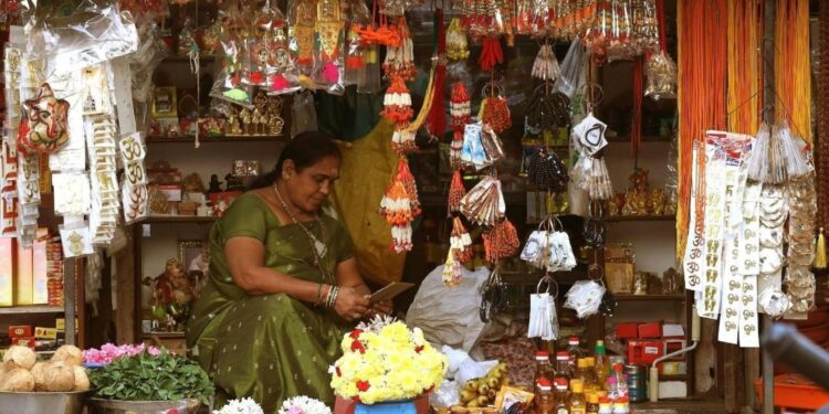Busy festive market in India during Eid al-Adha with shoppers purchasing clothing and food for the celebration