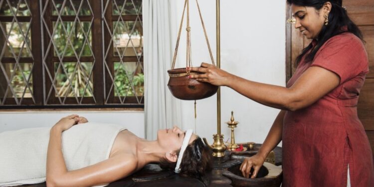 Ayurvedic therapist performing traditional oil massage at an Ayurveda retreat in Kerala India