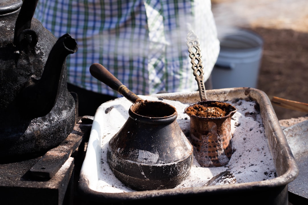 南インドのドリップコーヒー淹れの儀式の一環として、自宅でコーヒー豆を計量し挽く人物