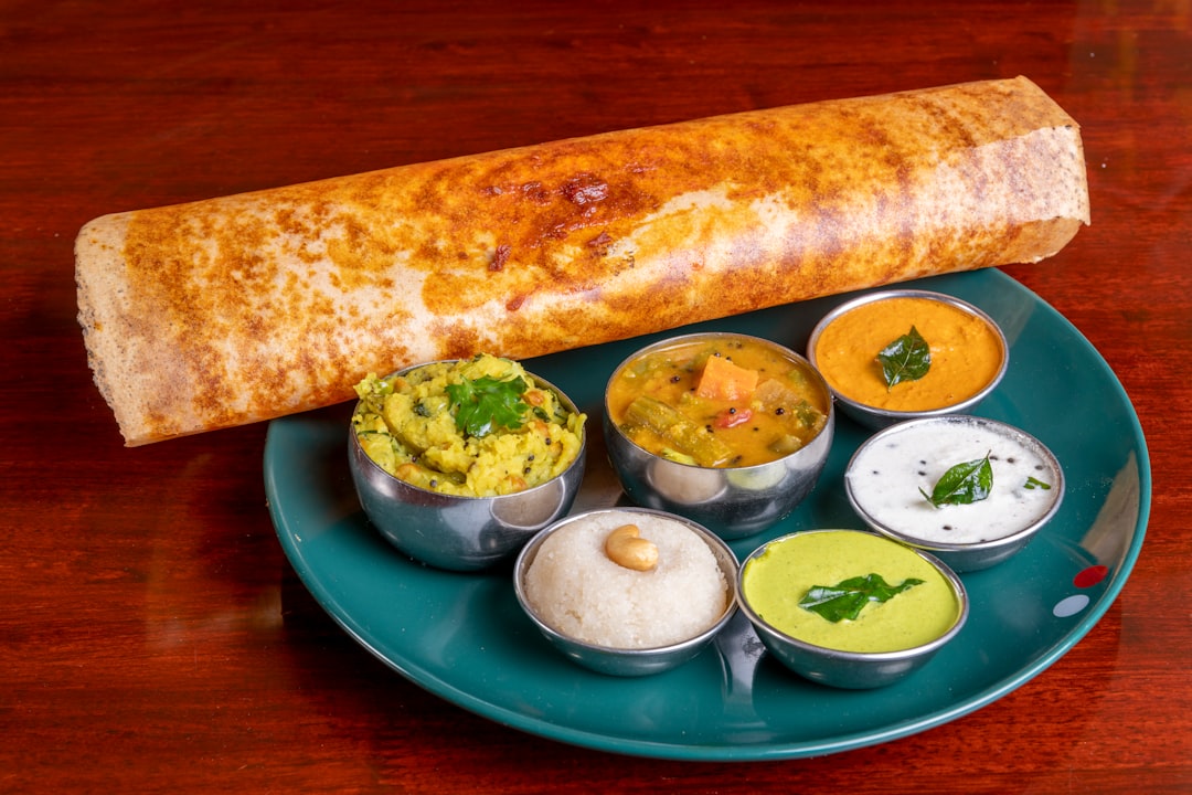 An Indian family sharing a South Indian dosa breakfast, a naturally gluten-free food served with sambar and coconut chutney.