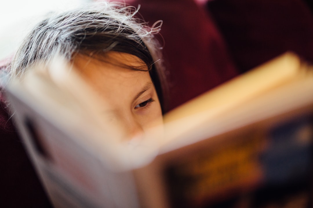 A young Indian girl engaged with a colourful illustrated Indian mythology book at a desk