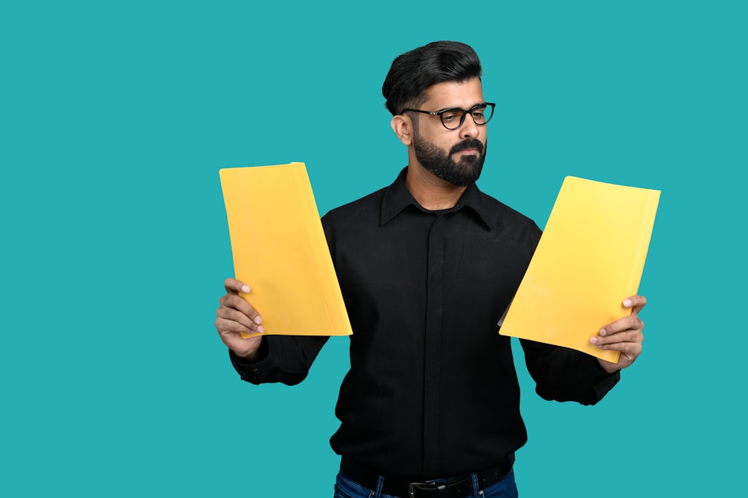 An Indian professional compares index funds performance data on printed documents at his office