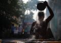 A young Indian woman touching her frizzy monsoon hair after stepping out in the rain on a humid June morning