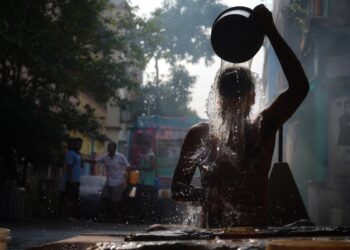 A young Indian woman touching her frizzy monsoon hair after stepping out in the rain on a humid June morning
