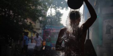 A young Indian woman touching her frizzy monsoon hair after stepping out in the rain on a humid June morning