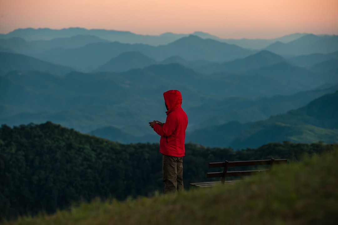 A visitor looks out over a misty green valley from a viewpoint at a hill station in Meghalaya
