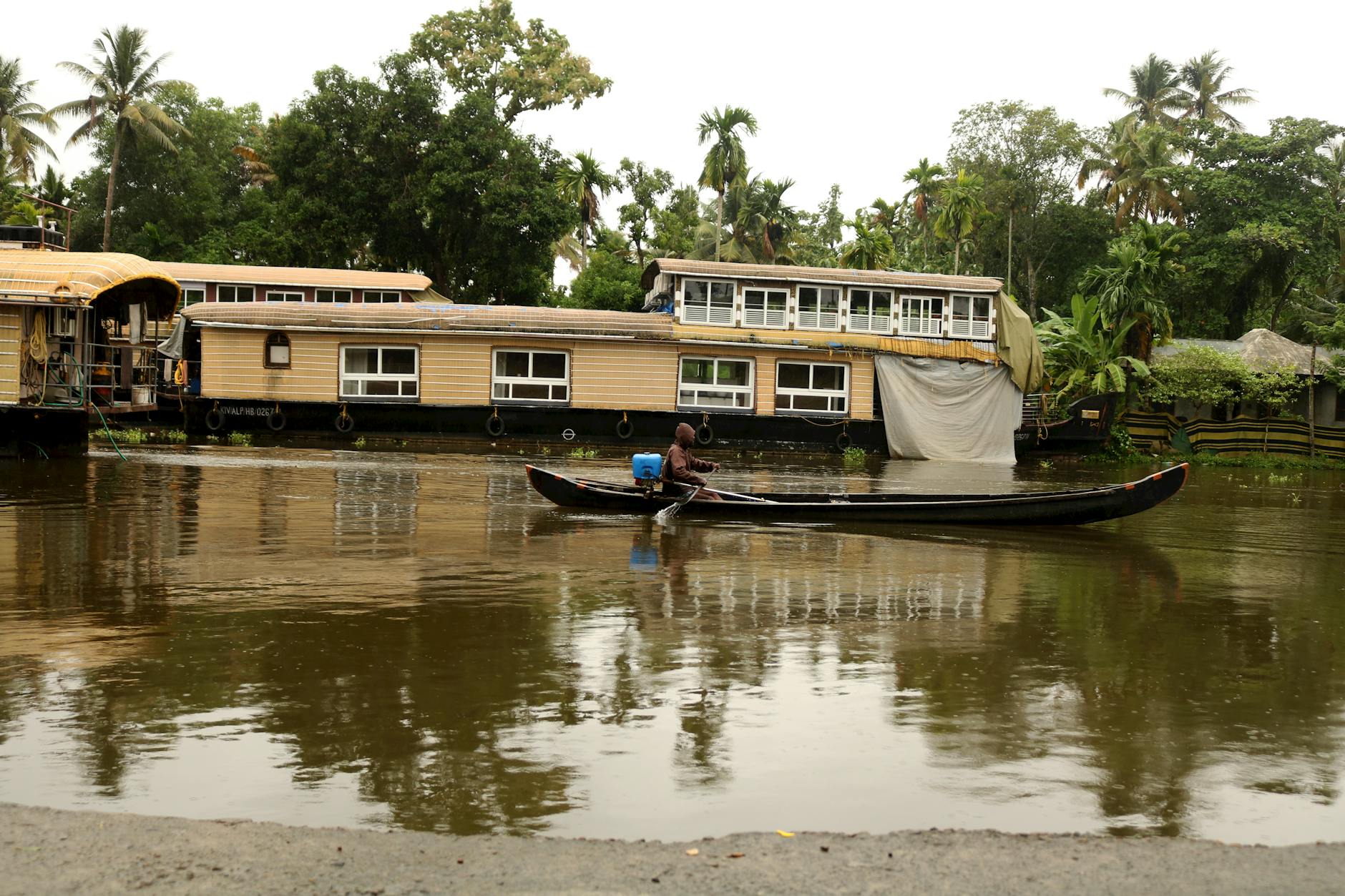 Des visiteurs explorant les backwaters du Kerala à bord d'une maison flottante traditionnelle pendant les voyages en Inde pendant la mousson