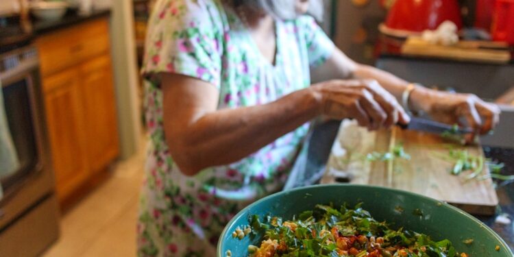 woman-composting-kitchen-scraps-unsplash - INDIAwebzine A young Indian woman sorting vegetable peels into a composting bin in her apartment kitchen
