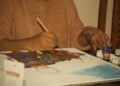 woman-painting-folk-art-paper-unsplash - INDIAwebzine A woman carefully creating a Madhubani painting on thick white paper with a fine-tipped brush