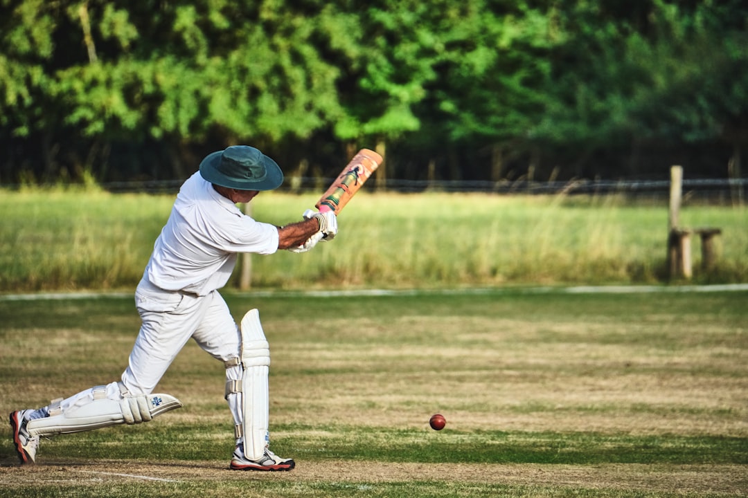 A batsman in white playing a cover drive at an English ground during the India vs England ODI series
