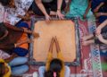 Une grand-mère enseigne à sa petite-fille comment jouer à des jeux indiens traditionnels sur un plateau en bois à la maison