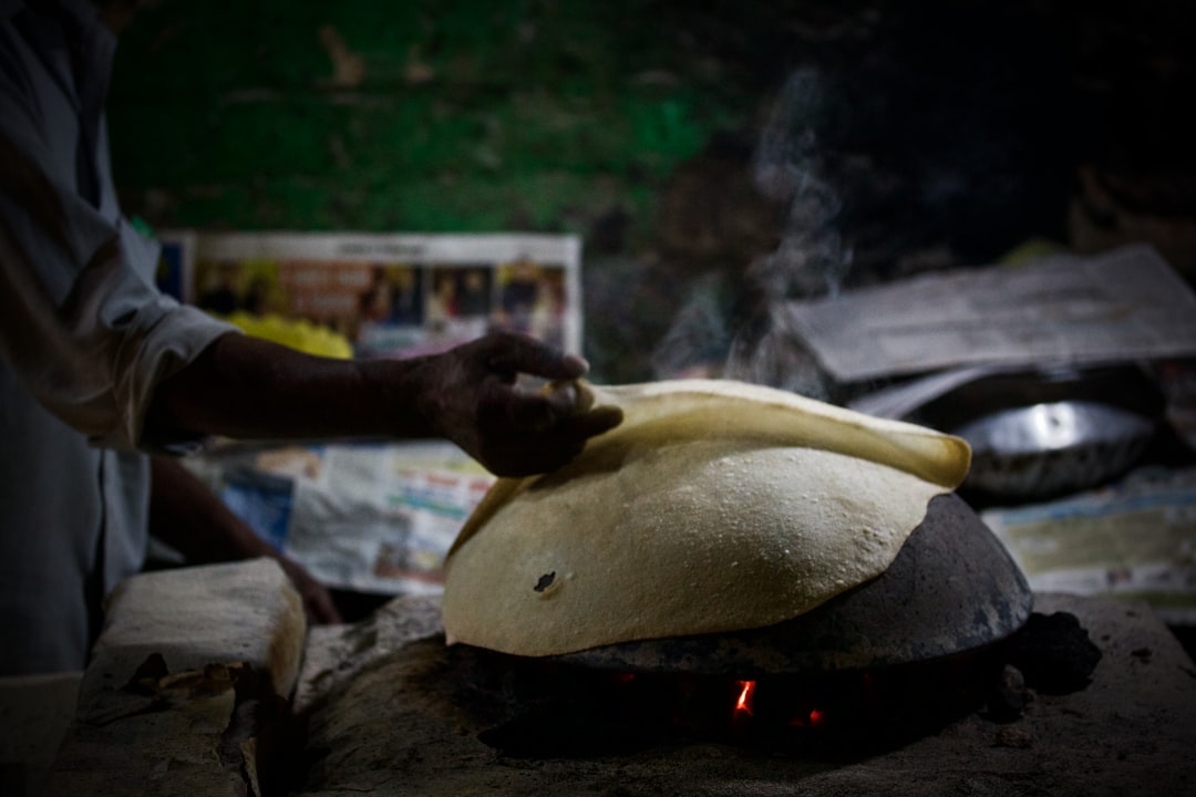 Una cocinera casera en India trabajando con harinas sin gluten incluyendo mijo y besan para hacer masa de roti