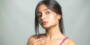 Young Indian woman applying a lightweight gel moisturizer as part of her monsoon skincare routine at home