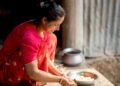 indian-woman-baking-with-flour-unsplash - INDIAwebzine A woman in an Indian kitchen measuring gluten-free flours to prepare homemade flatbread