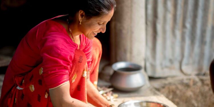 indian-woman-baking-with-flour-unsplash - INDIAwebzine A woman in an Indian kitchen measuring gluten-free flours to prepare homemade flatbread