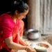 indian-woman-baking-with-flour-unsplash - INDIAwebzine A woman in an Indian kitchen measuring gluten-free flours to prepare homemade flatbread