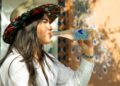 A young Indian woman drinking clean bottled water at a street market, protecting her gut health during monsoon season