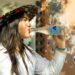 A young Indian woman drinking clean bottled water at a street market, protecting her gut health during monsoon season