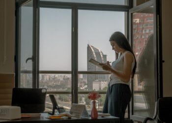 A focused Indian professional woman reviewing her NPS tier II account investment documents at a desk