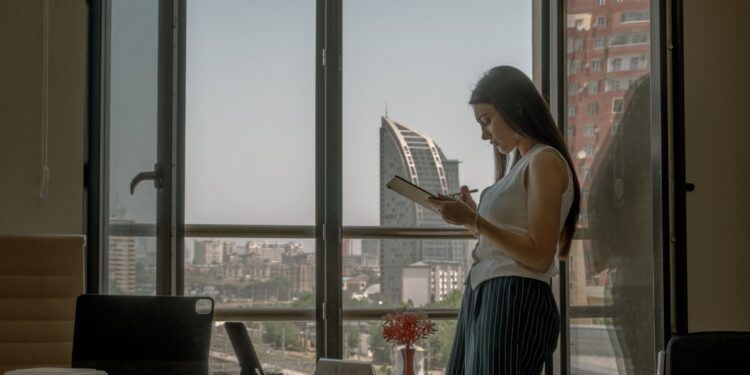 indian-woman-investor-reviewing-financial-documents-unsplash - INDIAwebzine A focused Indian professional woman reviewing her NPS tier II account investment documents at a desk