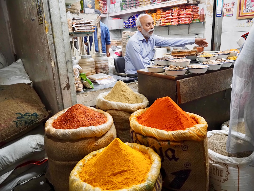 An Indian woman selects whole spices at a market in London, reflecting how the Indian diaspora keeps authentic flavorsalive.