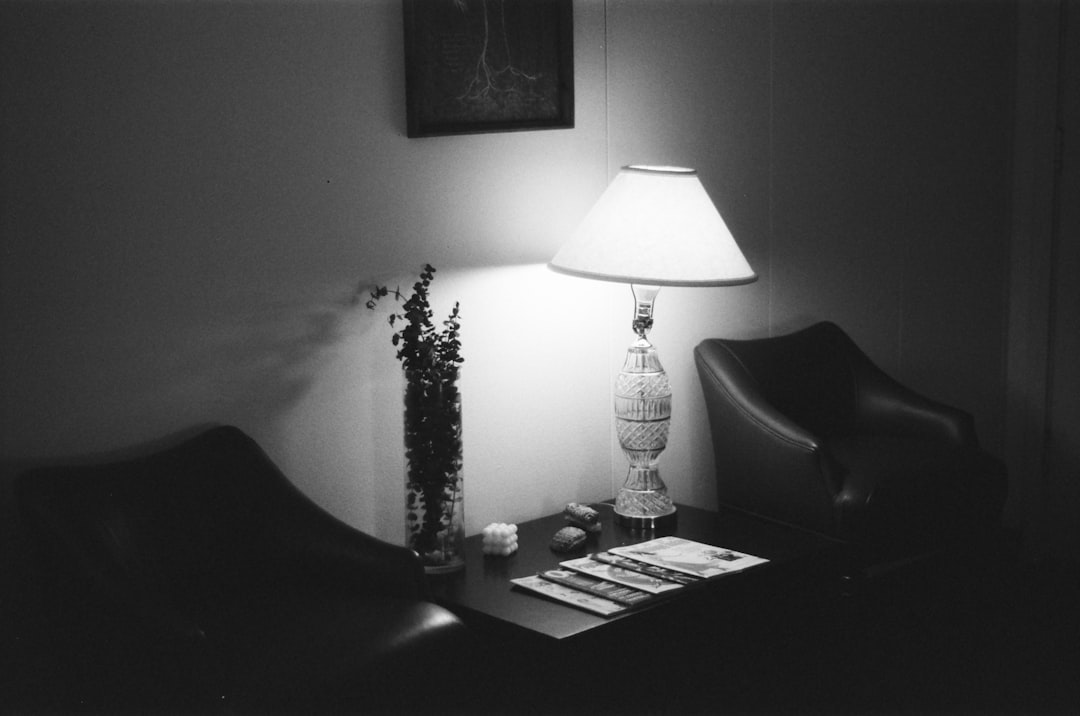 A person switches on a warm floor lamp beside a reading nook corner during the monsoon season