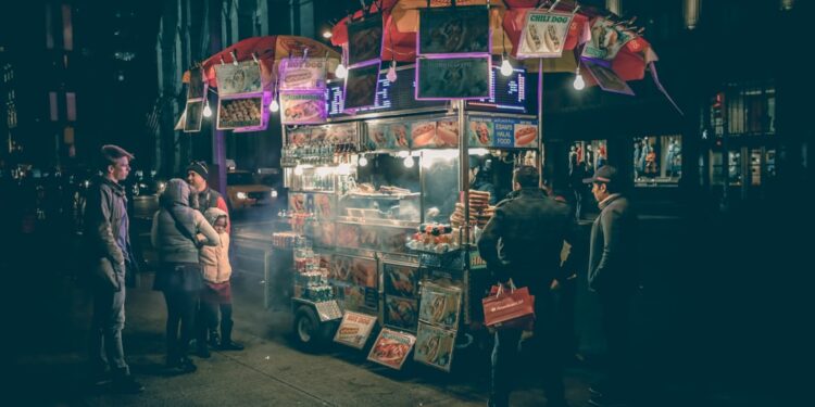 A smiling street vendor fries golden pakoras at a busy stall, capturing the joy of monsoon street food in Delhi
