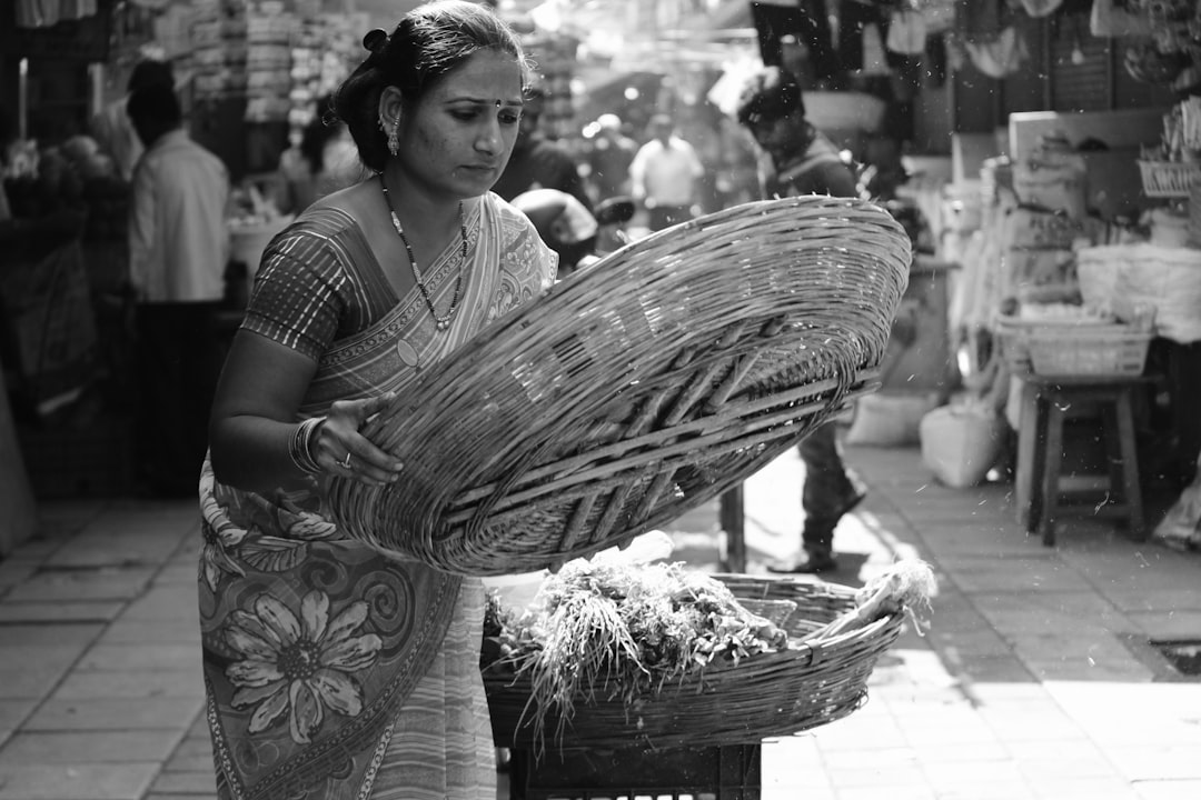 A young Indian woman holding bamboo storage baskets in a bright plastic-free kitchen space