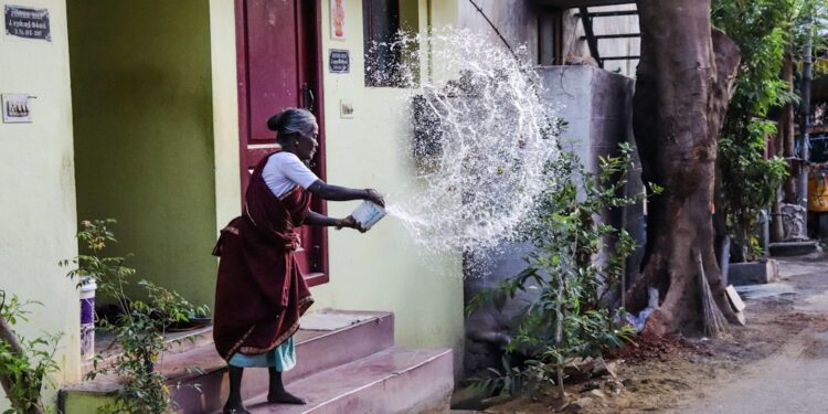 woman-collecting-rooftop-rainwater-india-unsplash - INDIAwebzine A woman using her rooftop rainwater harvesting setup during the monsoon season in an Indian home