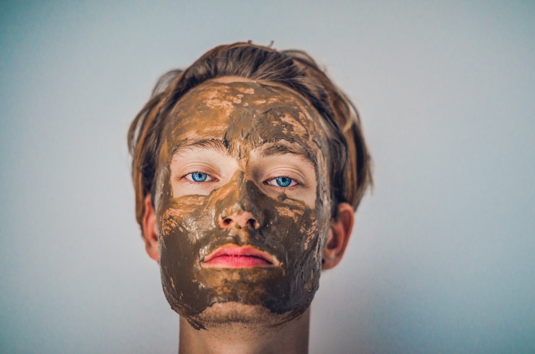 Woman applying a clay face mask to manage breakouts and oiliness in her monsoon skincare routine