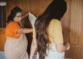 woman-folding-handloom-saree-indoors-unsplash - INDIAwebzine Indian woman carefully folding handloom cotton fabric indoors during the monsoon season