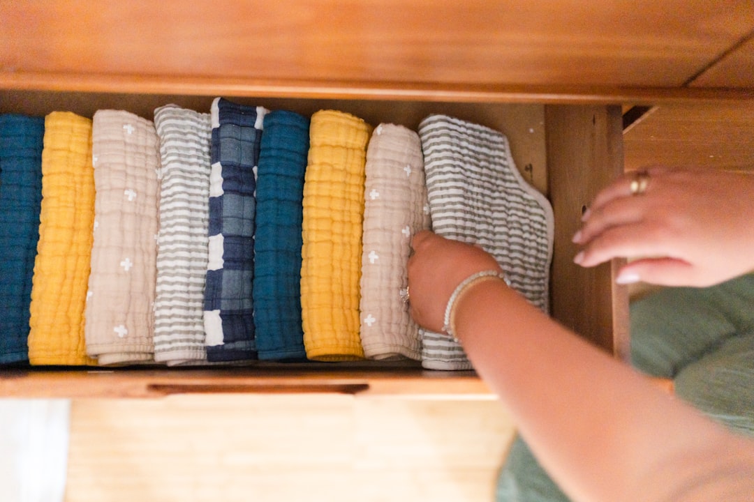 Woman placing a folded handloom cotton linen garment into a breathable cotton storage drawer