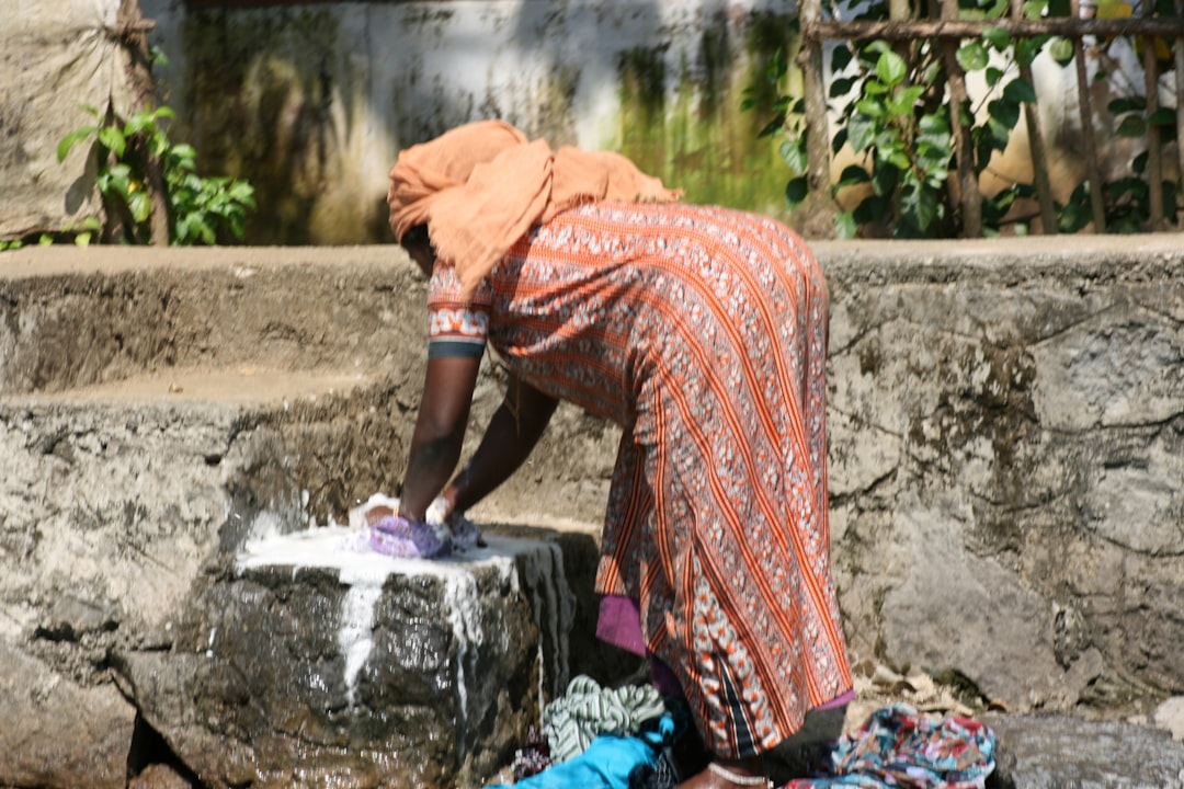Woman hand washing handloom cotton garment in cold water to protect the weave during monsoon