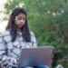 A young Indian woman studies on her laptop, representing India's demographic dividend generation preparing for the future.