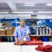 asian-textile-shop-worker-unsplash - INDIAwebzine An Indian-origin entrepreneur reviews fabric samples ahead of the festive procurement season in a Singapore textile shop