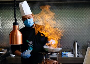 An Indian-origin chef carefully plates a monsoon flavours curry dish at a modern Singapore restaurant