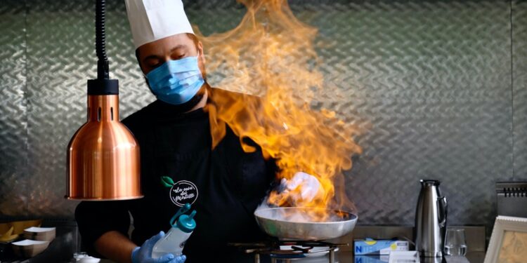 An Indian-origin chef carefully plates a monsoon flavours curry dish at a modern Singapore restaurant