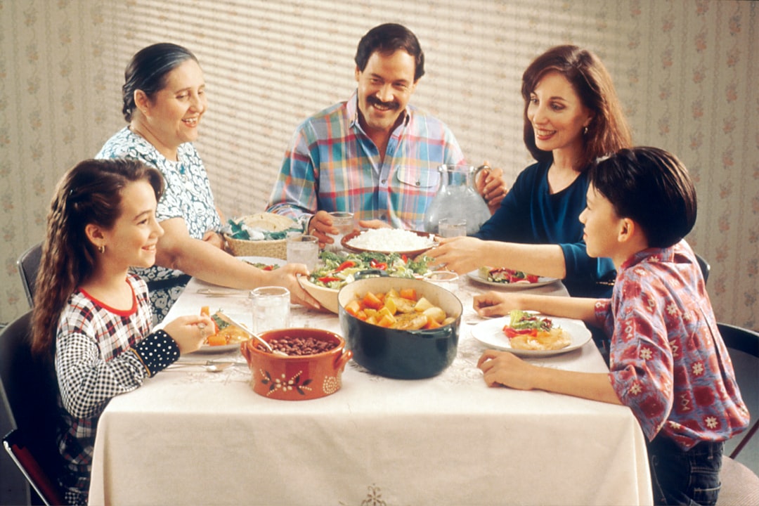 An Indian family serving small portions of festive dishes together, practising mindful food waste reduction.