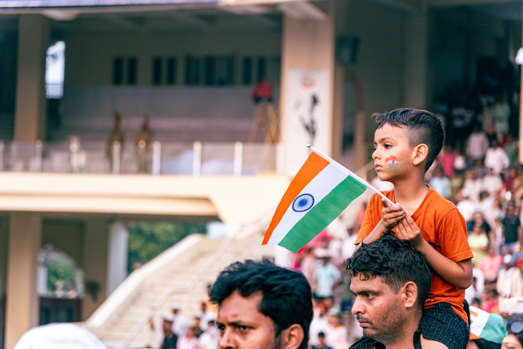 An Indian diaspora family gathers outdoors to watch a tricolour flag-hoisting ceremony on Independence Day.