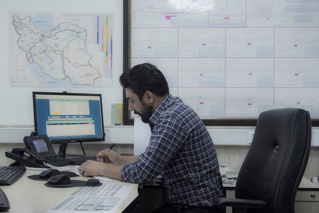 A focused Indian man analysing mutual fund SIPs performance data on printed charts at a co-working table