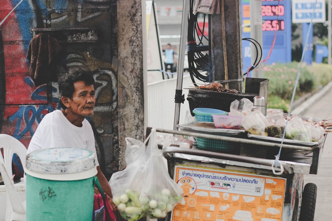 An Indian-origin street food vendor in Bangkok presents a dish rooted in classic monsoon flavours to a waiting diner