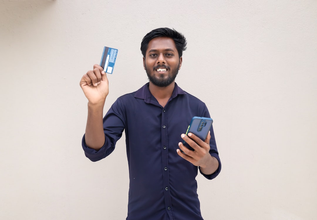 A young Indian entrepreneur checks his PPF account balance on a mobile banking app to track tax savings.