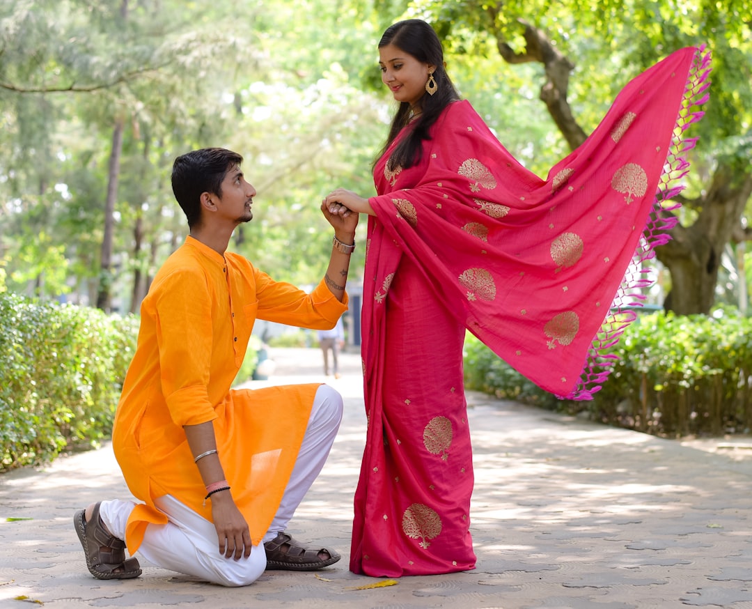 A couple dressed in lightweight khadi and linen monsoon outfits standing on a wet street in an Indian city