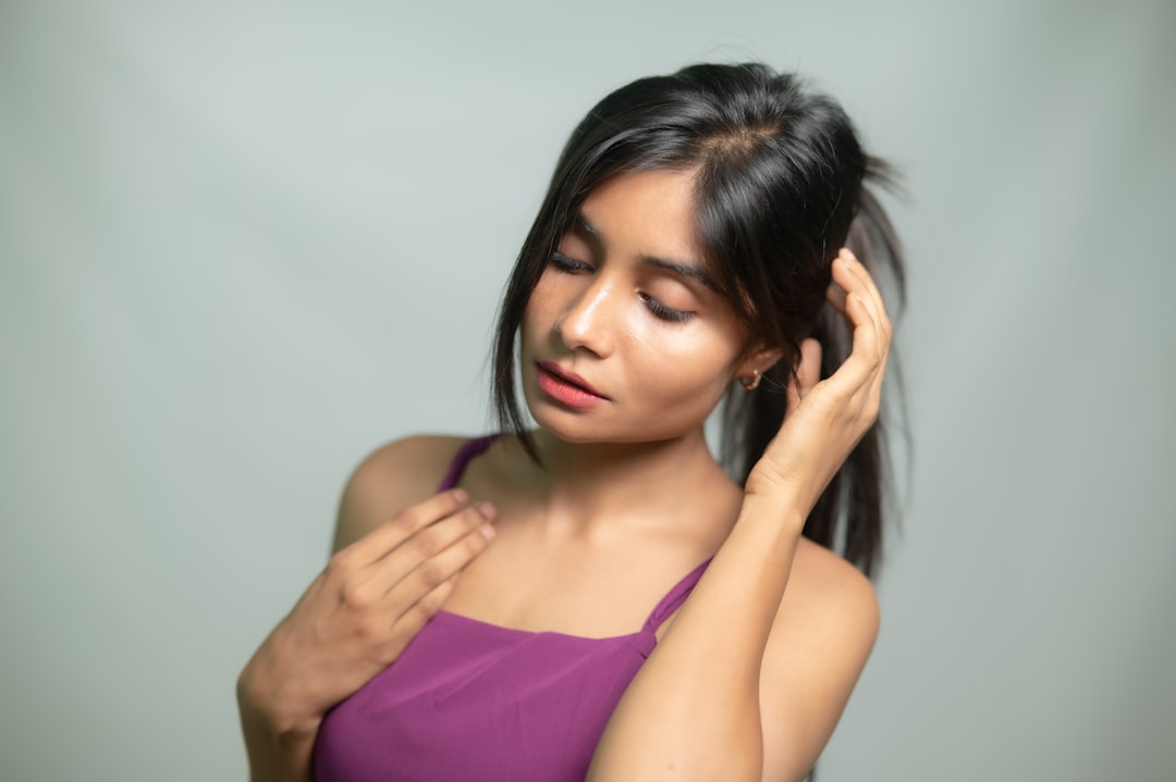 A young Indian woman applying nourishing oil as part of her weekly scalp care routine