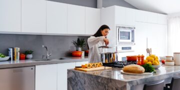 indian-woman-festive-kitchen-planning-unsplash - INDIAwebzine An Indian woman writing a meal plan at her kitchen table, working to reduce food waste before the festive season begins.
