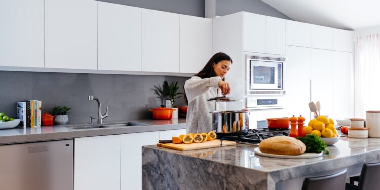indian-woman-festive-kitchen-planning-unsplash - INDIAwebzine An Indian woman writing a meal plan at her kitchen table, working to reduce food waste before the festive season begins.