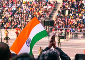 A woman in traditional dress holds the Indian tricolour at an Indian diaspora Independence Day ceremony abroad.